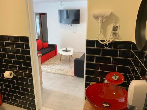 łazienka z czerwoną toaletą i salon w obiekcie Willa Sudecka w mieście Racibórz