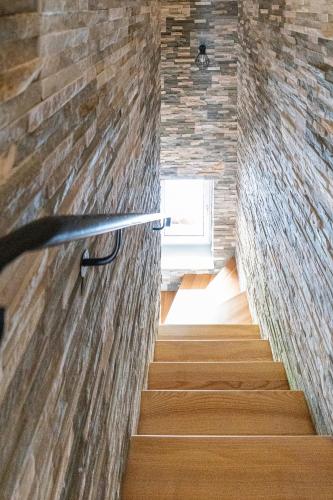 a staircase with a brick wall and a window at Apartmány pod Rozsutcom - Zaťkov dvor in Terchová