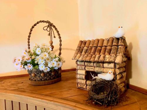 a table with a bird house and a basket of flowers at Nitsa Guest House in Gori