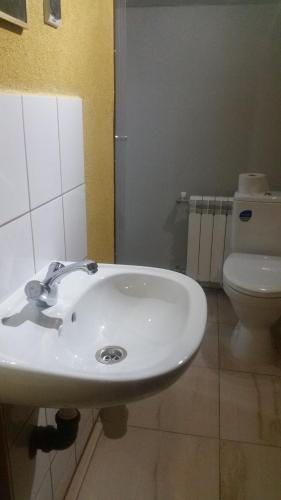 a bathroom with a white sink and a toilet at Pokoje Gościnne "U Karola" Pracownicze in Ścinawa