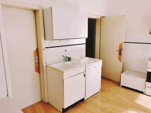 Baño blanco con lavabo y espejo en Apartma Rekar - a house, where you can relax in the embrace of nature, en Jesenice