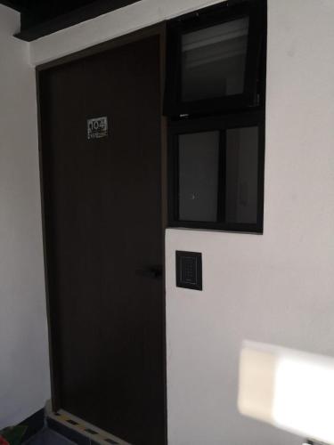 a black door with a microwave above a refrigerator at Tepeyac 402 in León