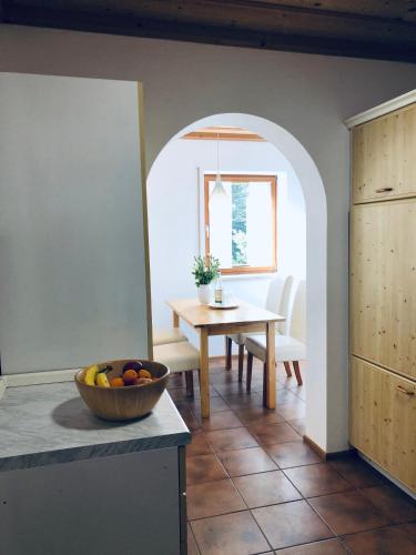 a kitchen with a table and a bowl of fruit on a counter at Ferienwohnungen Hecker in Bad Gögging