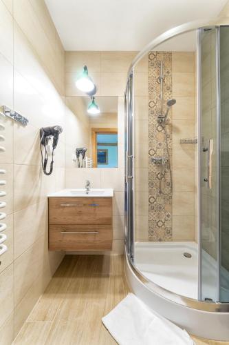 a bathroom with a shower and a sink at Karcma Hajnos Pokoje in Białka Tatrzańska