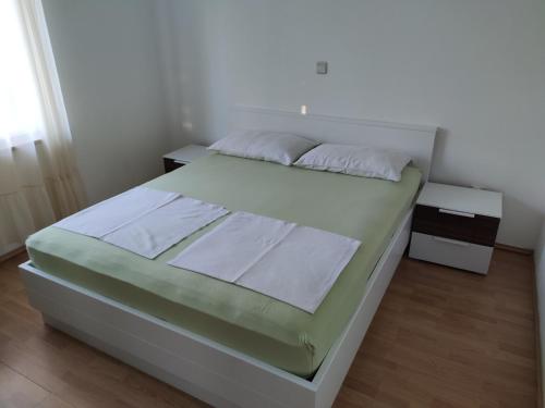 um quarto com uma cama grande e lençóis brancos em Apartment with private garden and terrace em Crikvenica
