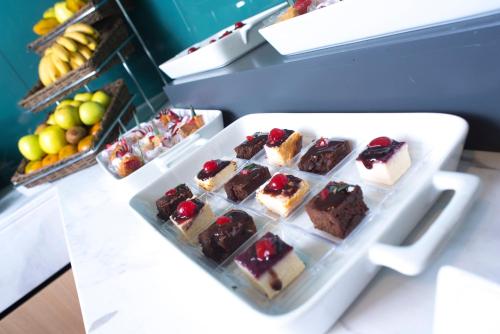 a tray of desserts on a counter with a plate of food at Holiday Inn Morelia by IHG in Morelia