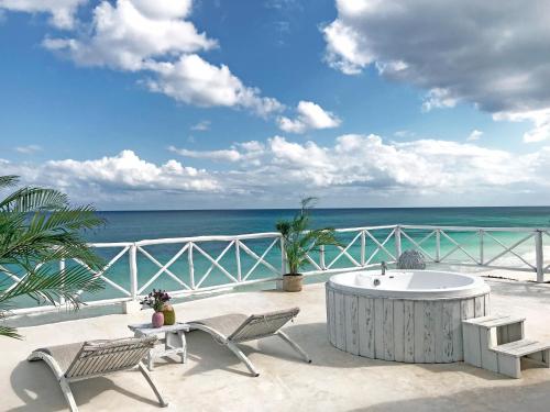 a patio with a table and chairs and the ocean at Coco Unlimited in Tulum