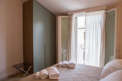 um quarto com 2 pares de chinelos numa cama com uma janela em B&B Borgo Marinaro em Porto San Giorgio