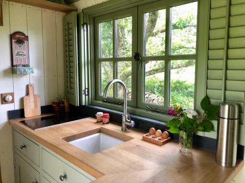 cocina con fregadero y ventana en The Dordogne Huts with Private Pool and Jacuzzi en Payzac