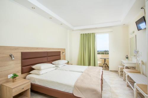 a bedroom with a bed and a desk and a window at Billy's Studios in Faliraki