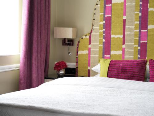 a bed room with a pink and white bedspread at Hayes Hotel in Thurles