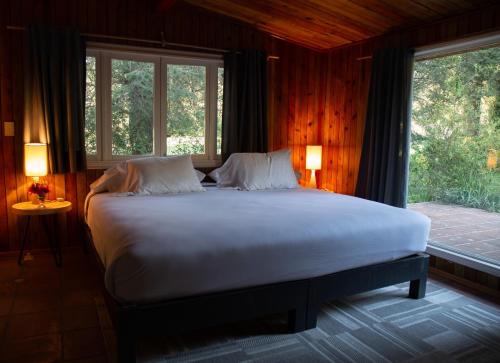 a bedroom with a large bed with two windows at Rancho Viejo in El Aguaje