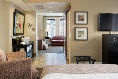 a living room with a couch and a television on the wall at The Sofia Hotel in San Diego