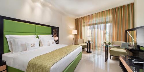 a hotel room with a bed and a television at Bahi Ajman Palace Hotel in Ajman 