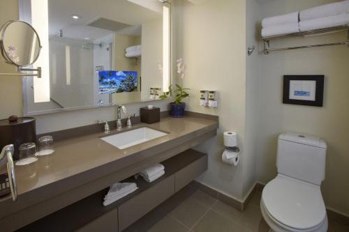 a bathroom with a sink and a toilet and a mirror at Bucuti & Tara Boutique Beach Resort - Adult Only in Palm-Eagle Beach