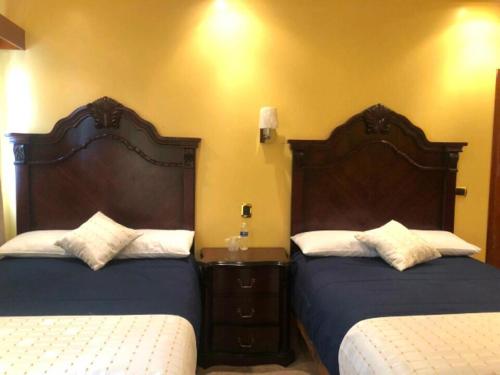 two beds in a hotel room with two beds at Hotel la finca in Ezequiel Montes