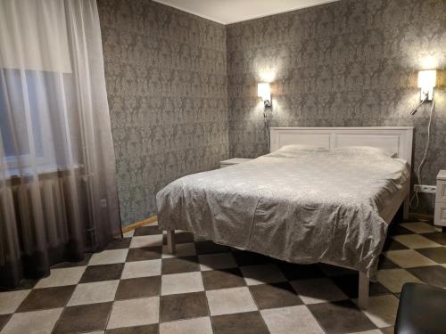 a bedroom with a bed and a checkered floor at ReeDe Villa in Otepää