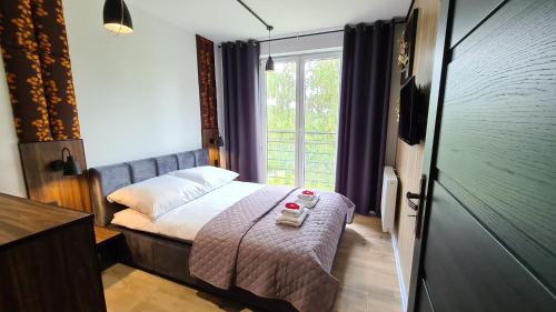 a small bedroom with a bed and a window at Lux Apartment Loft in Polanica-Zdrój