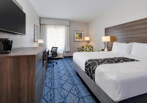 a hotel room with a large bed and a desk at La Quinta by Wyndham Denton - University Drive in Denton