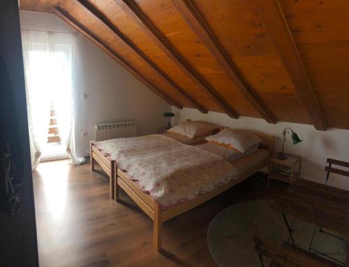 a bedroom with a large bed with a wooden ceiling at Holiday Home-kuća GORICA VERDE in Fužine