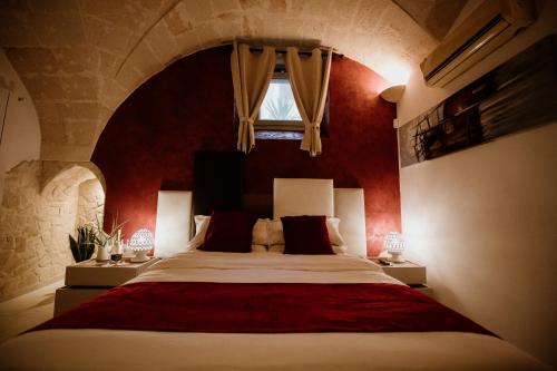 a bedroom with a large bed with a red wall at Pacuvius Home Suite B&B in Brindisi