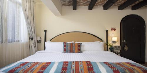 
a bedroom with a bed and a dresser at Hacienda El Santuario San Miguel de Allende in San Miguel de Allende
