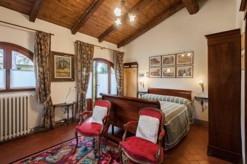 a bedroom with a bed and two chairs at Casa Santa Lucia, Noto Barocca in Castiglion Fiorentino