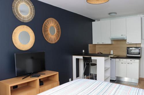 une cuisine avec des placards blancs et un mur noir dans l'établissement Studio design proche Défense-Paris, à Rueil-Malmaison