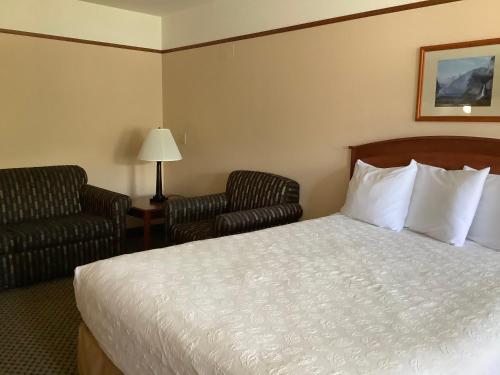 a hotel room with a bed and two chairs at Luxury Inn & Suites in Silverthorne
