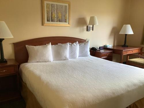 a hotel room with a bed with white pillows at Luxury Inn & Suites in Silverthorne