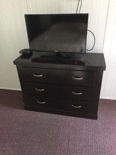 a black dresser with a tv on top of it at BONITTO INN® Monterrey Norte in Monterrey