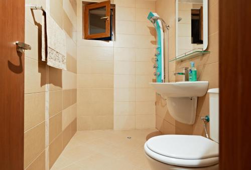 a bathroom with a toilet and a sink at Stanny Court ApartHotel in Nesebar