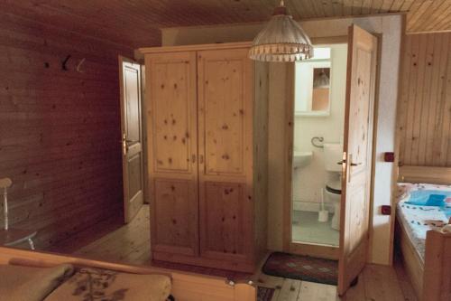 a bedroom with a large wooden cabinet and a bed at PENZIJON URBANC in Lovrenc na Pohorju