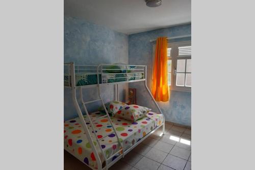 een slaapkamer met een stapelbed in een kamer bij Kaz a Man Fey in Petit-Canal