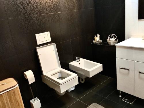 a bathroom with a toilet and a sink at Cara Apartment - 5 min walk to the beach (Delfinariu - bd. Mamaia) in Constanţa