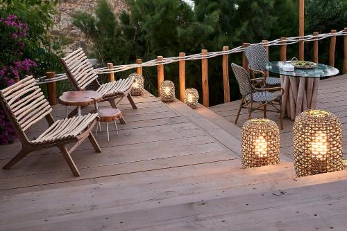 a wooden deck with chairs and a table with lights at Palladium Hotel in Platis Yialos Mykonos