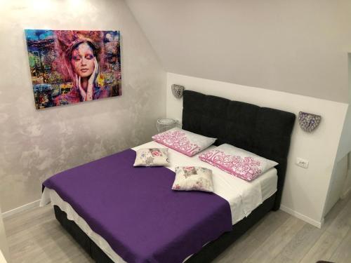 sypialnia z fioletowym łóżkiem z obrazem na ścianie w obiekcie Apartment Vid w Splicie