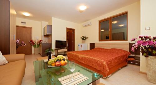 a bedroom with a bed and a table with a bowl of fruit at Stanny Court ApartHotel in Nesebar