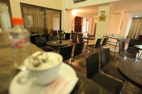 a restaurant with tables and chairs and a bowl of food at Hotel Kratis in Kratovo