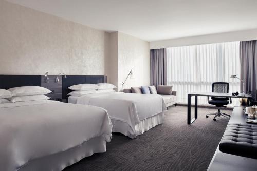 een hotelkamer met 2 bedden en een bank bij Wyndham Monterrey Ambassador Centro in Monterrey