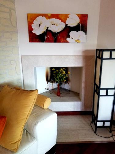 a living room with a white fireplace with a painting at Villa Antonella in Villasimius