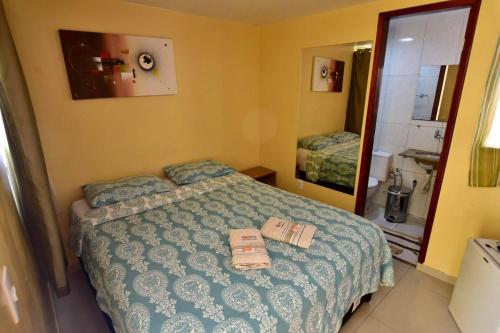 a bedroom with a bed with two towels on it at Pousada do Turista in Fortaleza