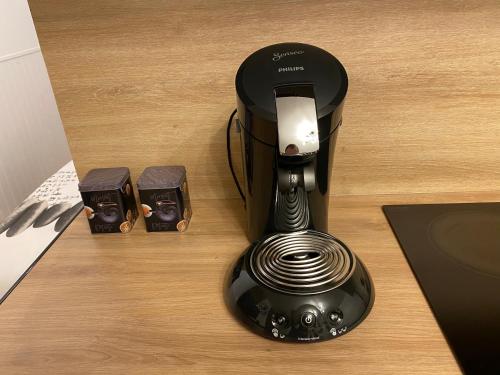 une machine à expresso assise sur une table avec deux batteries dans l'établissement jolie logement proche de la mer, à Berck-sur-Mer