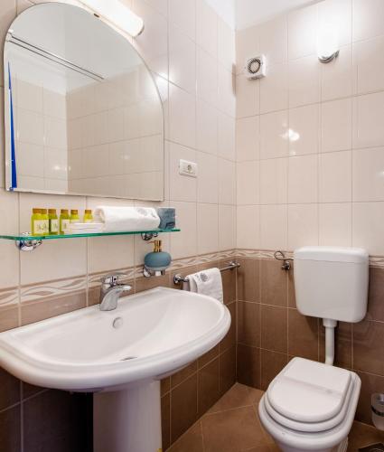 a bathroom with a sink and a toilet and a mirror at Lavica Seaside Apartments, Podstrana in Podstrana