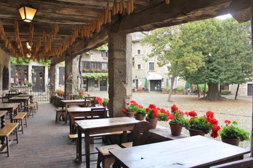 an outdoor patio with tables and chairs and flowers at Hostellerie du Vieux Pérouges in Pérouges