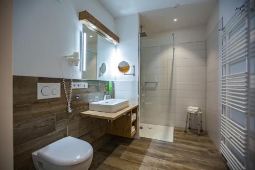 a bathroom with a white toilet and a sink at Hotel Friedenseiche in Benediktbeuern