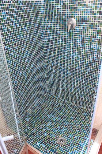a shower with a blue and green tiled ceiling at Villa Antonella in Villasimius