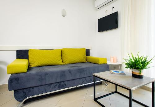 a blue couch with yellow pillows in a living room at Lavica Seaside Apartments, Podstrana in Podstrana