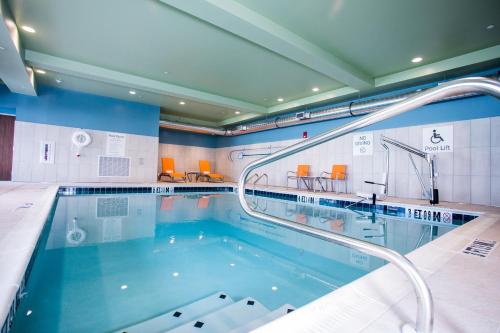 a swimming pool with a water slide in it at Holiday Inn Express & Suites Rehoboth Beach, an IHG Hotel in Rehoboth Beach