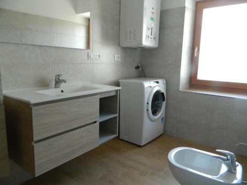 a bathroom with a washing machine and a sink at Appartamento Rosina, per 4/6 persone. In centro in Coredo